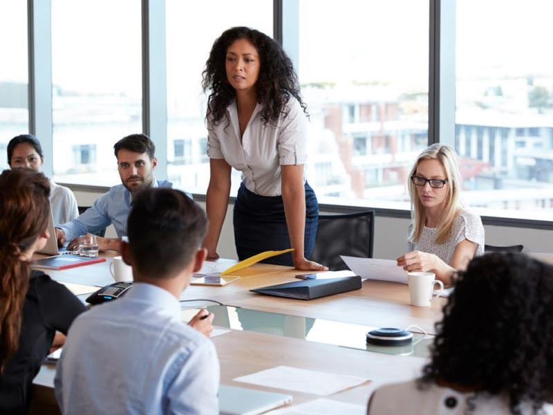 Woman medical leader advocating and speaking up for herself in a meeting.